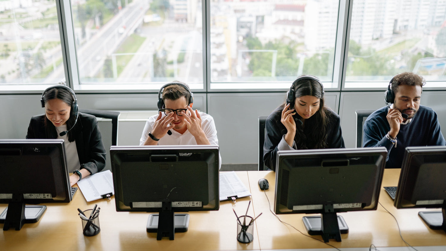 people sitting by their computers with headsets